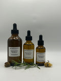 Restore & Grow Root Serum in 4 fl oz, 2 fl oz, and 1 fl oz amber dropper bottles with rosemary and dried botanicals
